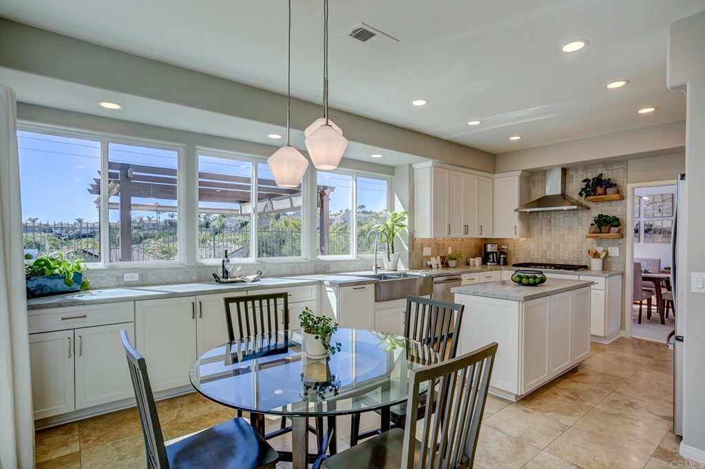 1732 Blackbird Circle Carlsbad, CA 92011 - Photo 12 of 39 a kitchen with stainless steel appliances granite countertop a stove a refrigerator a kitchen island a dining table and chairs