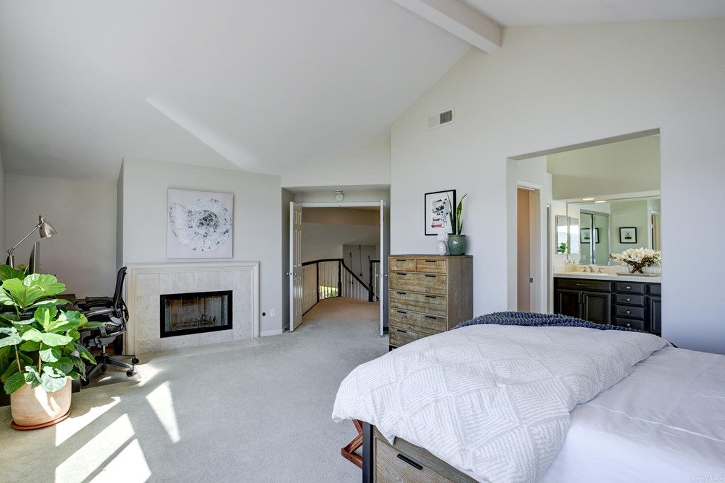 1732 Blackbird Circle Carlsbad, CA 92011 - Photo 28 of 39 a bedroom with a bed and a fireplace
