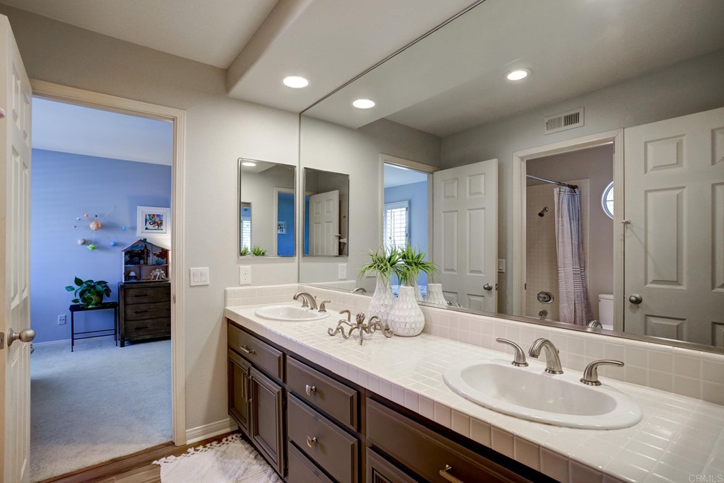 1732 Blackbird Circle Carlsbad, CA 92011 - Photo 31 of 39 a bathroom with a sink double vanity granite and a mirror