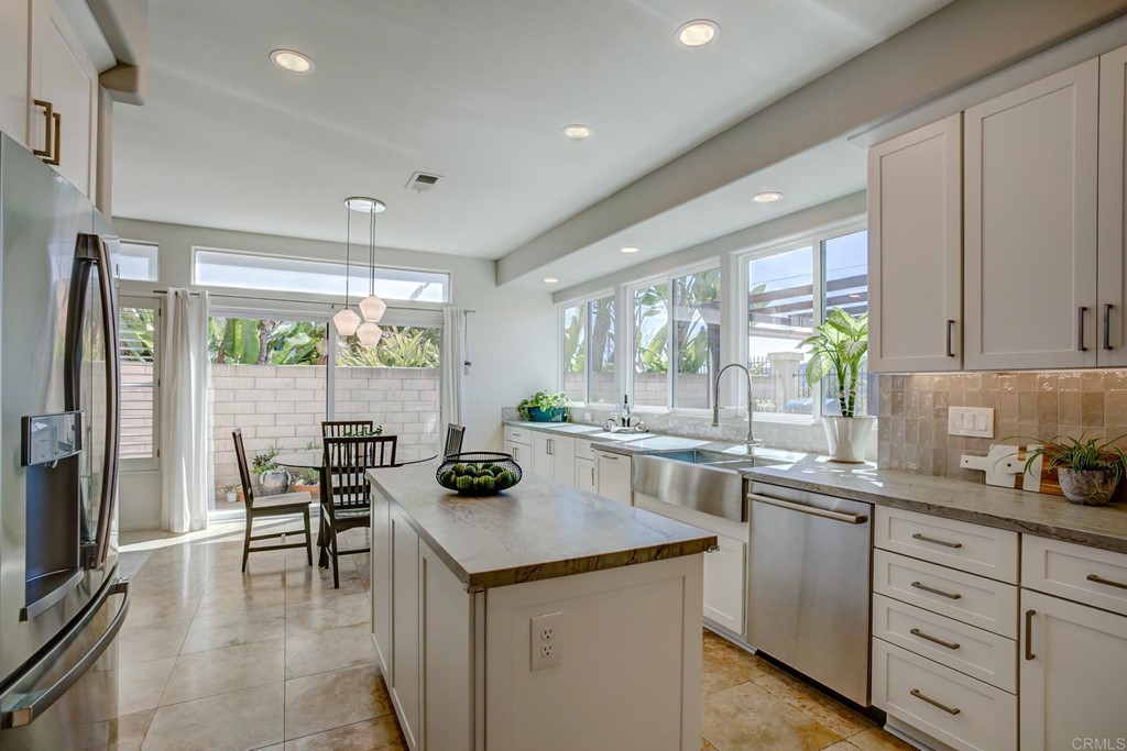 1732 Blackbird Circle Carlsbad, CA 92011 - Photo 9 of 39 a kitchen with a table chairs refrigerator and cabinets