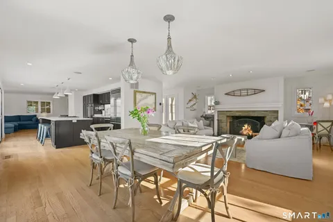 a view of a dining room with furniture wooden floor and a fireplace