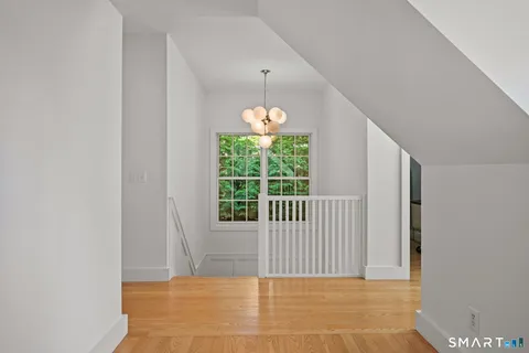 a view of a hallway with windows and chandelier