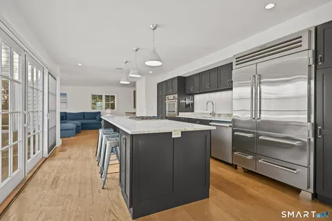 a kitchen with kitchen island a counter top space a sink stainless steel appliances and cabinets