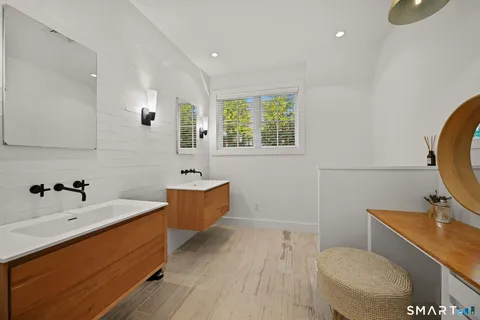 a bathroom with a sink a toilet and mirror