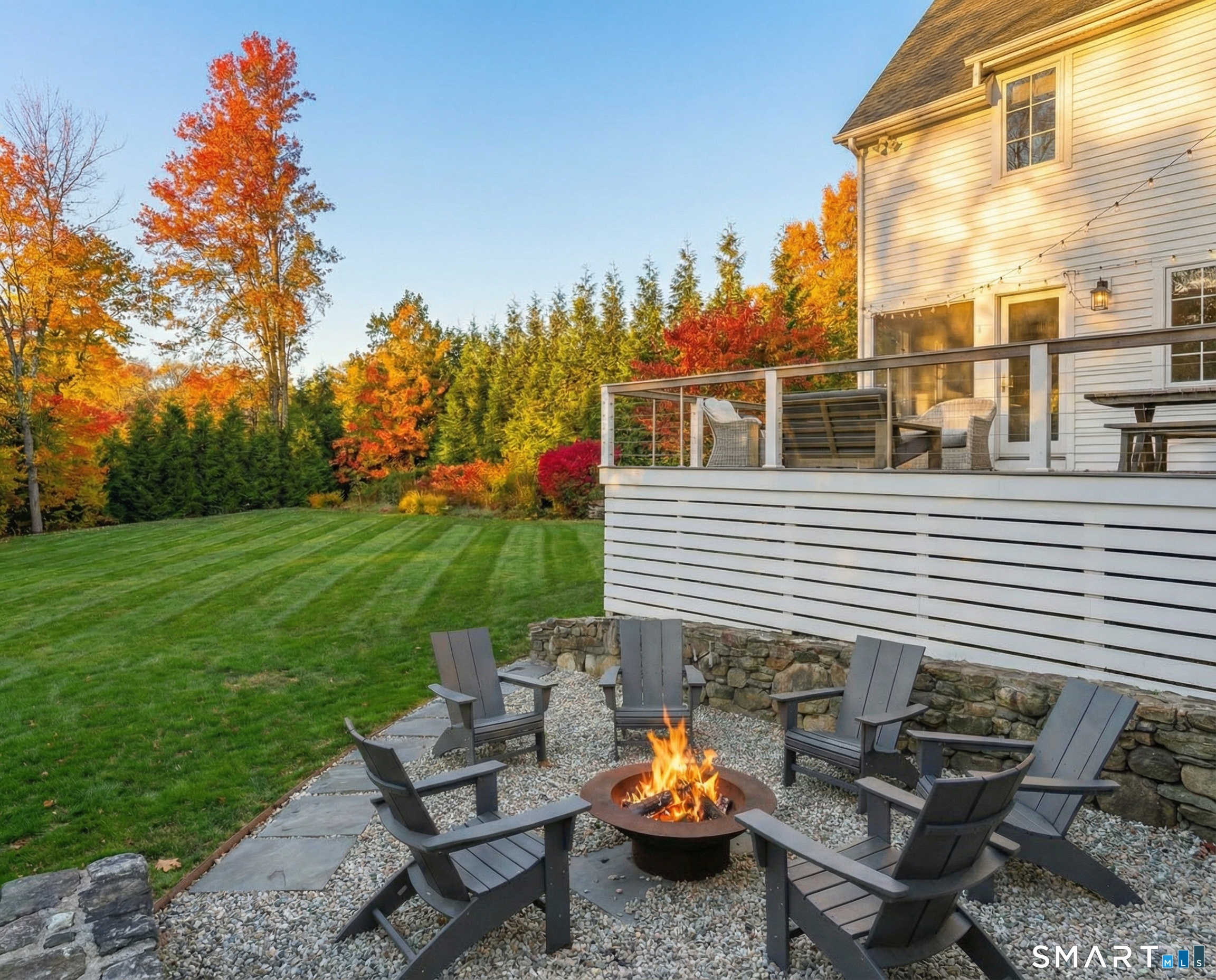 150 Hillspoint Road Westport, CT 06880 - Photo 33 of 40 a view of a patio with a table and chairs and a fire pit