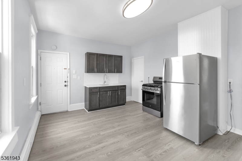 215 Delaware Street, Unit 6 Elizabeth Port, NJ 07206 - Photo 2 of 11 a kitchen with stainless steel appliances a refrigerator and a television