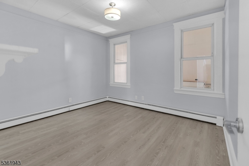 215 Delaware Street, Unit 6 Elizabeth Port, NJ 07206 - Photo 8 of 11 an empty room with wooden floor and windows