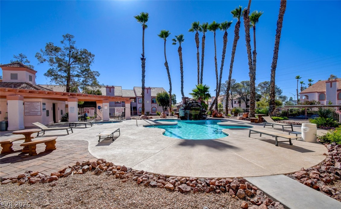 7570 West Flamingo Road, Unit 119 Las Vegas, NV 89147 - Photo 14 of 15 A resort-style oasis offers a sculpted swimming pool with a cascading waterfall.