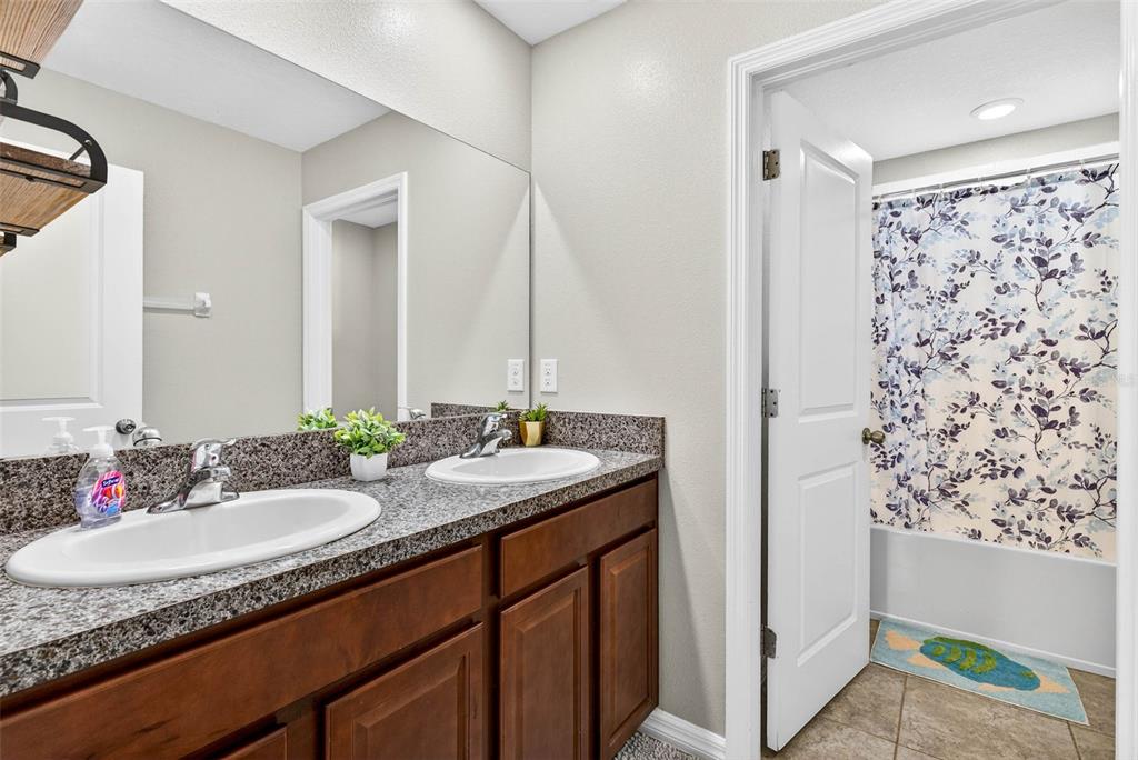 9616 Lemon Drop Loop Sun City Center, FL 33573 - Photo 41 of 53 a bathroom with a granite countertop sink and a mirror
