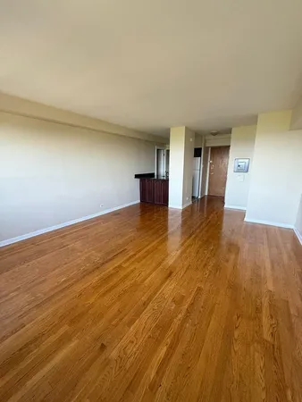 a view of a room with wooden floor and a window