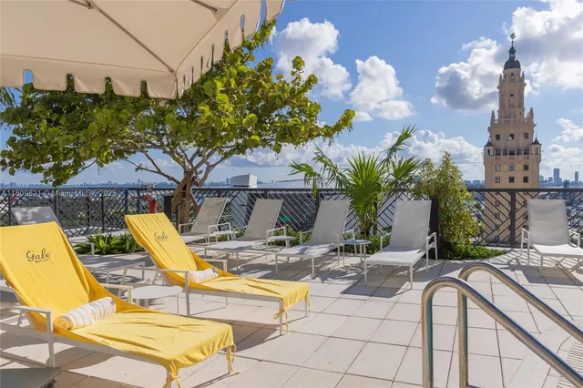 a view of backyard with swimming pool and seating space