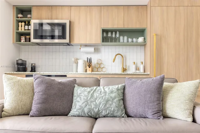 a living room with a couch and a kitchen counter top oven