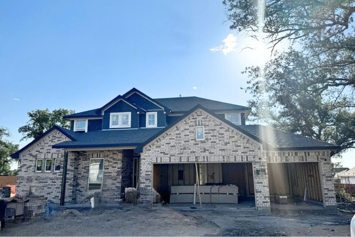 View of front of property featuring brick siding, a hot tub, and a porch