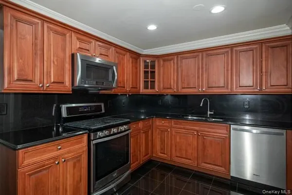 a kitchen with stainless steel appliances granite countertop a stove microwave and sink