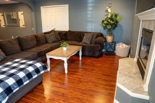 a living room with furniture and a wooden floor
