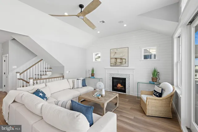 a view of a dining room and livingroom with furniture wooden floor kitchen view and a chandelier