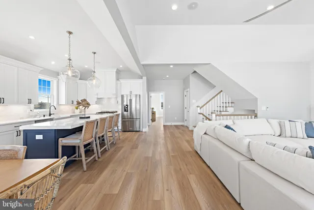 a large kitchen with granite countertop a stove a sink a dining table and chairs