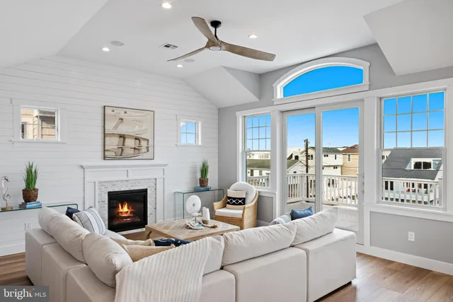 a living room with furniture kitchen view and a wooden floor