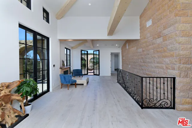 a very nice looking room with large windows and a potted plant