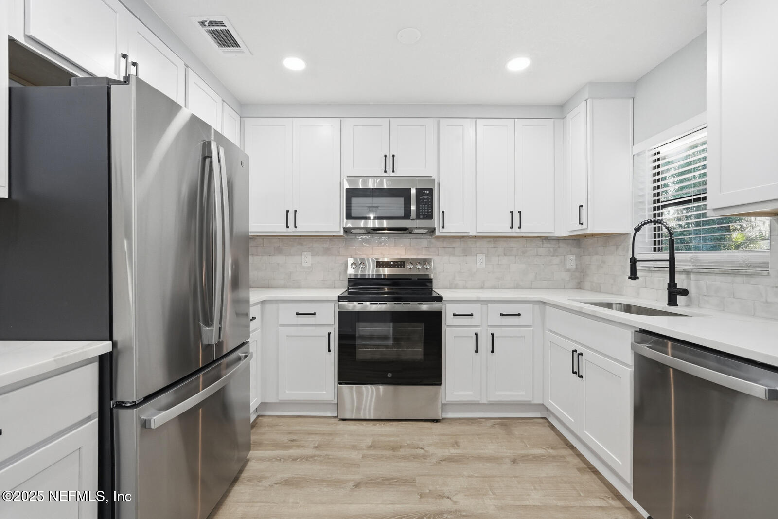 341 Alabama Avenue Palatka, FL 32177 - Photo 16 of 47 a kitchen with a refrigerator sink and stainless steel appliances
