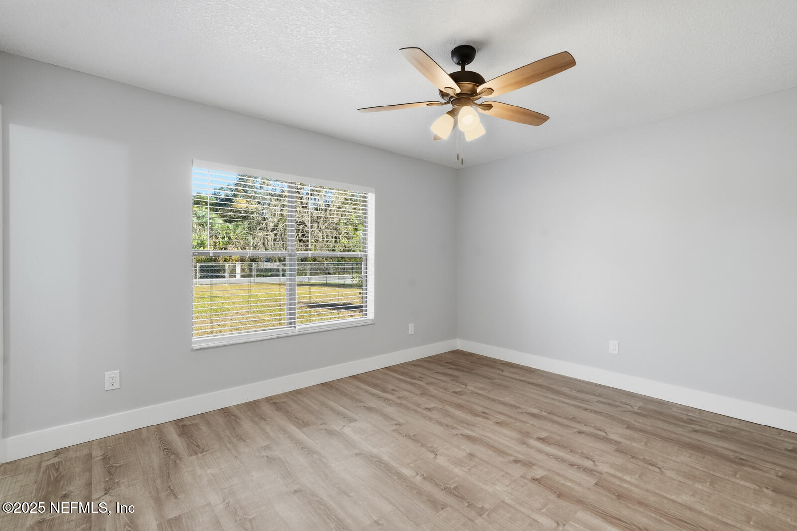 341 Alabama Avenue Palatka, FL 32177 - Photo 30 of 47 an empty room with wooden floor fan and windows