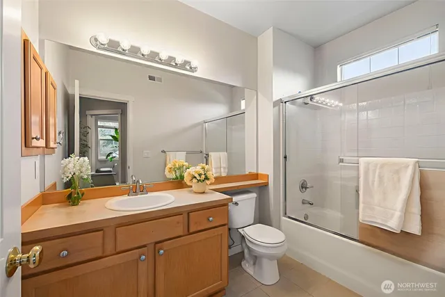a bathroom with a double vanity sink toilet and shower