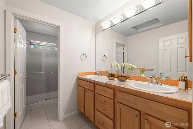 a bathroom with a double vanity sink mirror and shower