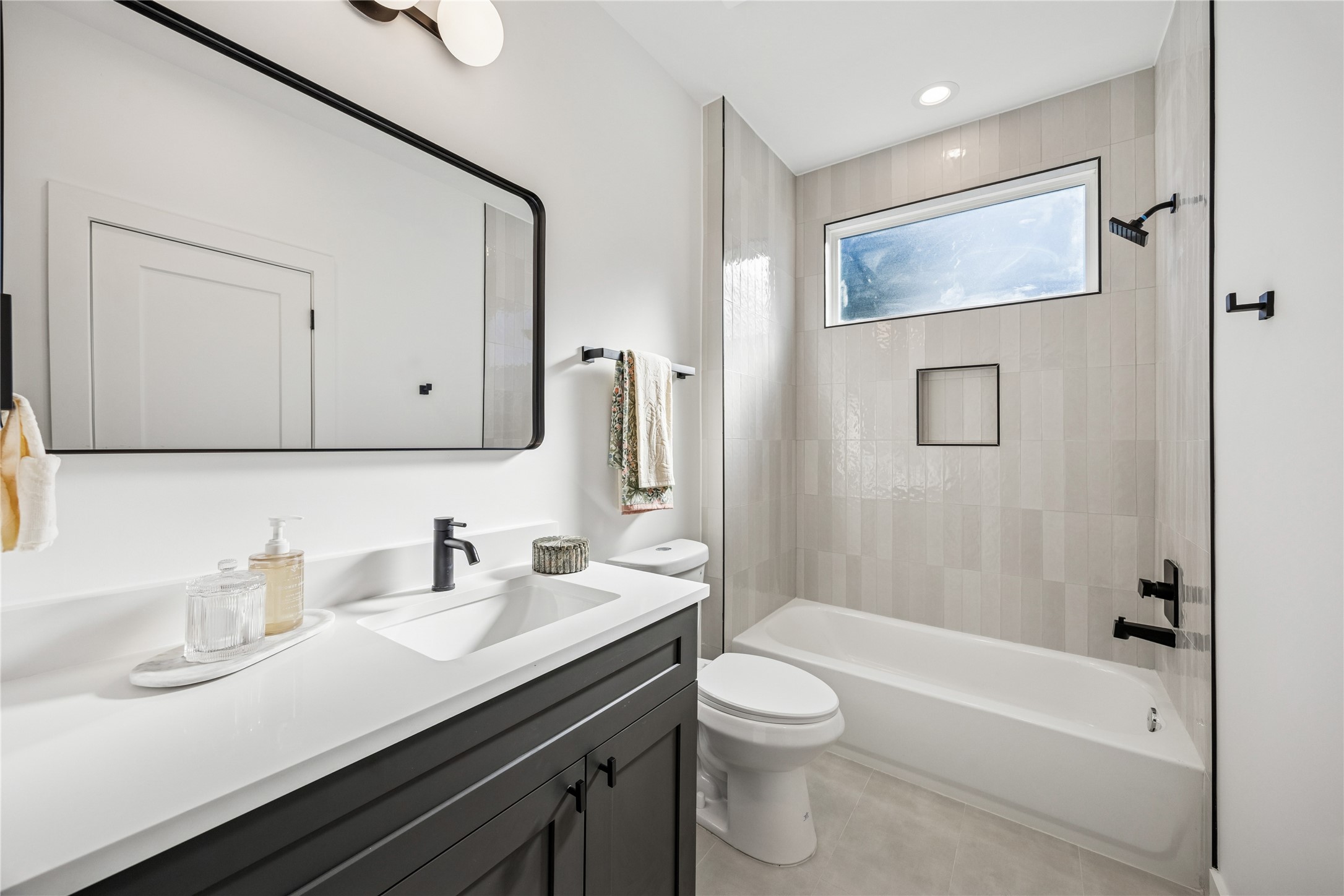3008 Lamar Street Houston, TX 77003 - Photo 32 of 33 a bathroom with a granite countertop sink a toilet a mirror and shower