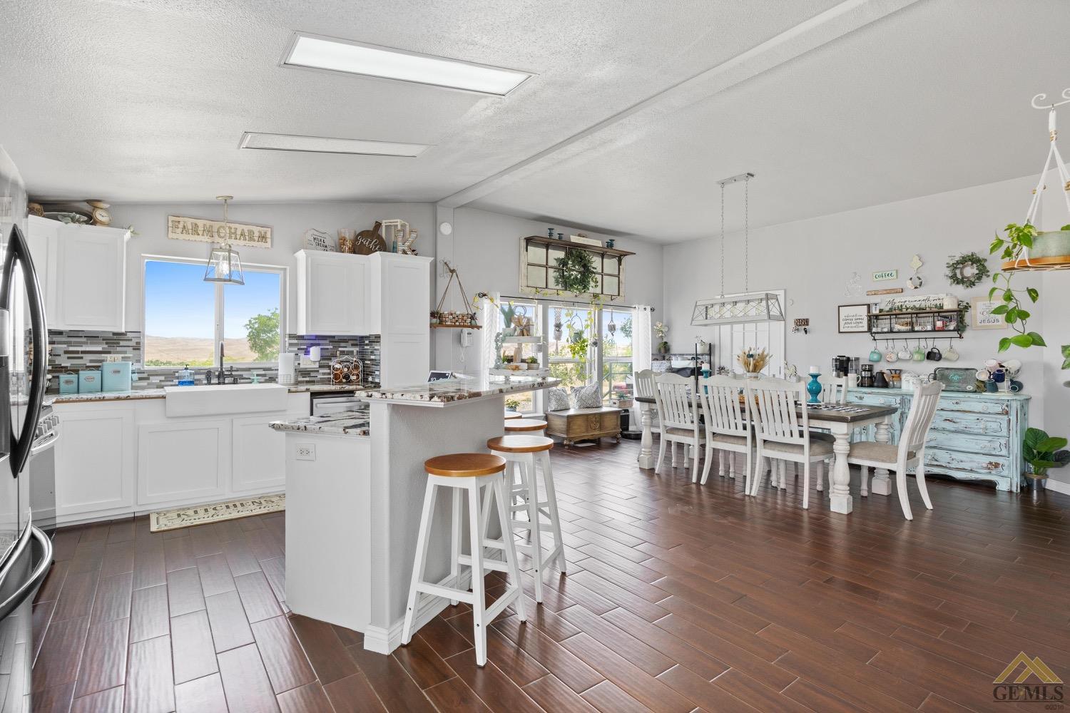 Undisclosed Address Bakersfield, CA 93308 - Photo 17 of 39 a kitchen with a dining table chairs refrigerator and cabinets