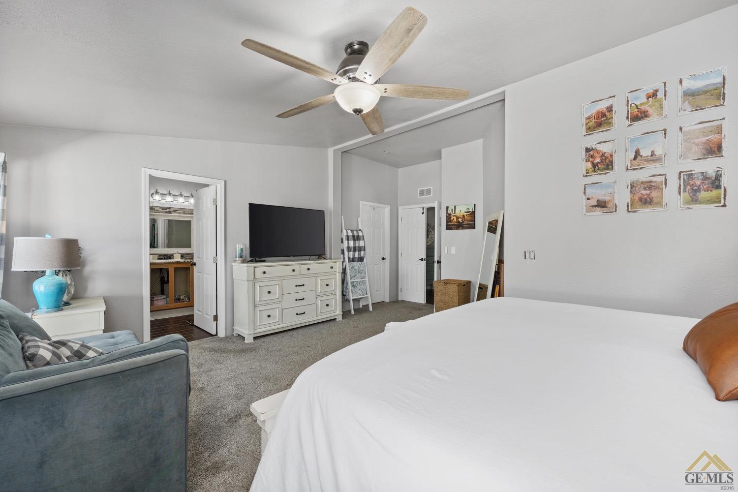 Undisclosed Address Bakersfield, CA 93308 - Photo 26 of 39 a spacious bedroom with a bed a flat screen tv and a couch