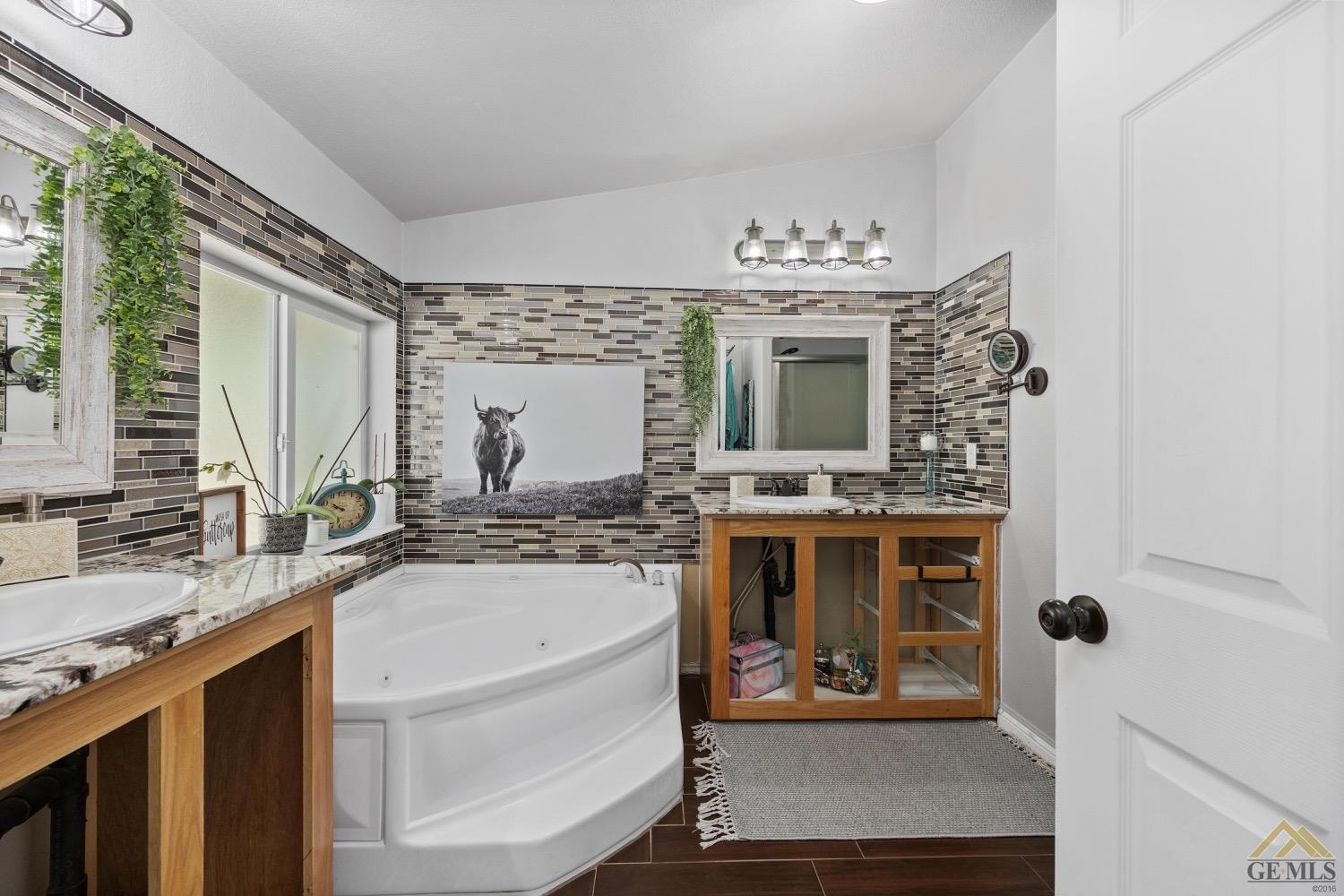 Undisclosed Address Bakersfield, CA 93308 - Photo 27 of 39 a bathroom with a tub sink and mirror