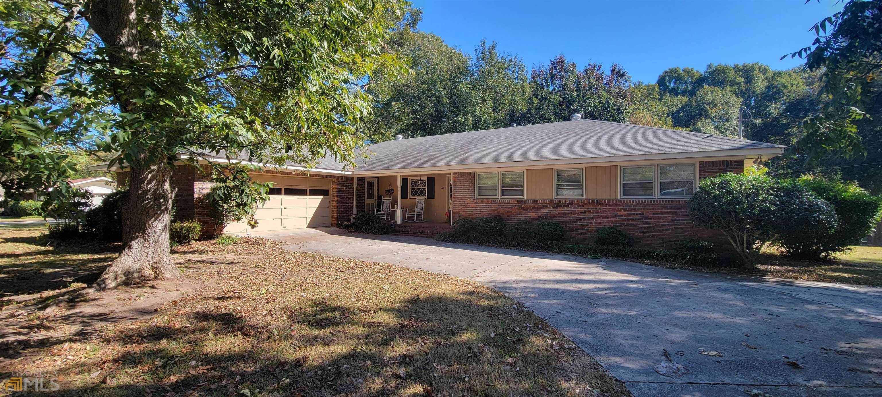 a front view of a house with a yard and tree s
