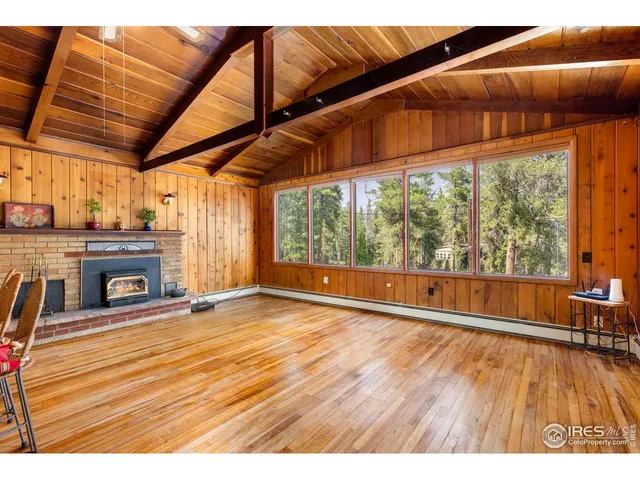 a view of empty room with wooden floor and fireplace