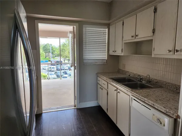 a kitchen with granite countertop a refrigerator sink and stove