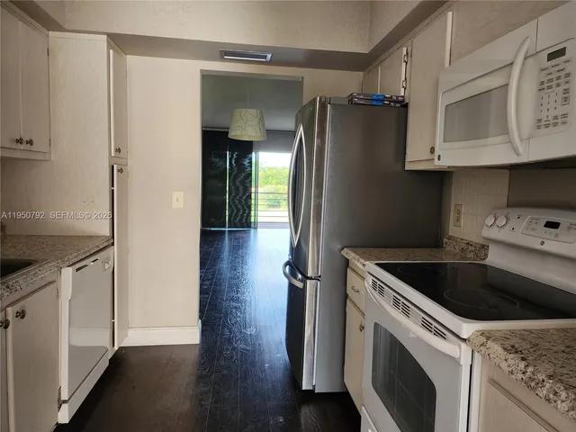 a kitchen with a refrigerator sink and cabinets