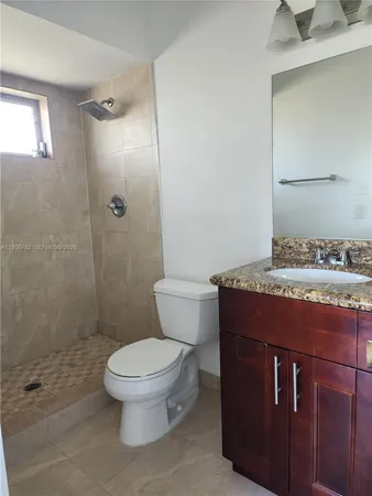 a bathroom with a granite countertop toilet a sink and a shower