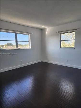 a view of wooden floor and windows in a room