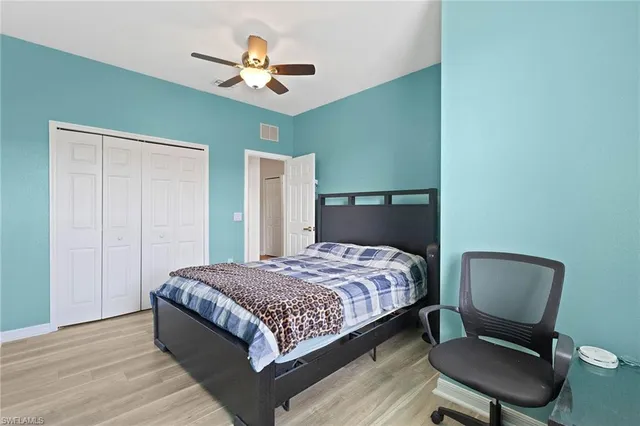 a bedroom with a bed a chair and a chandelier