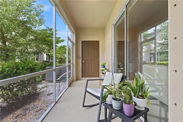 a balcony with table and chairs with wooden floor