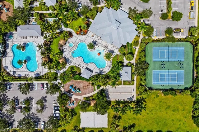 an aerial view of a house with a yard and large trees