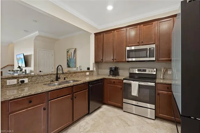 a kitchen with sink a microwave a stove and cabinets