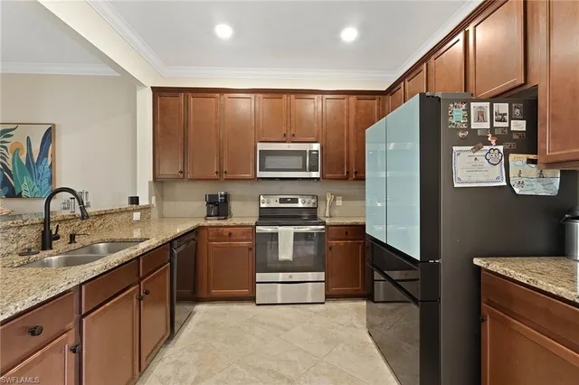 a kitchen with stainless steel appliances granite countertop a refrigerator stove and sink