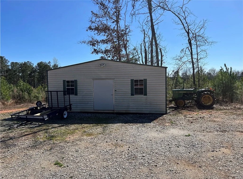 1 State Rd S-4-555 Iva, SC 29655 - Photo 11 of 27 This sturdy outbuilding offers ample storage for tools and equipment amidst a natural landscape.