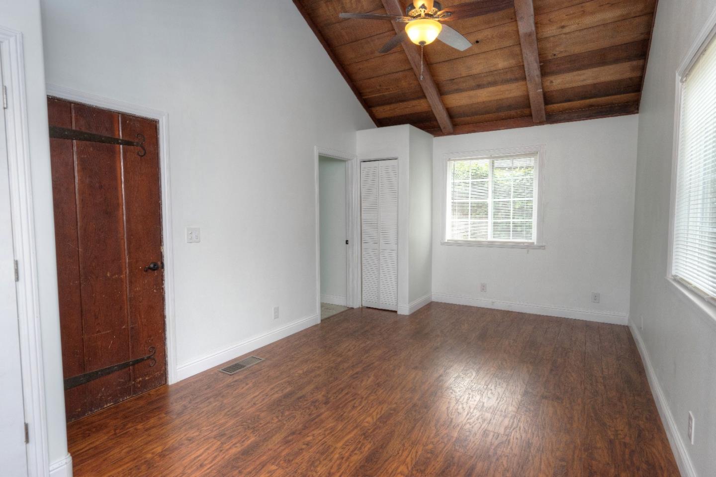 197 Ramona Avenue Pacifica, CA 94044 - Photo 16 of 26 an empty room with wooden floor fan and windows