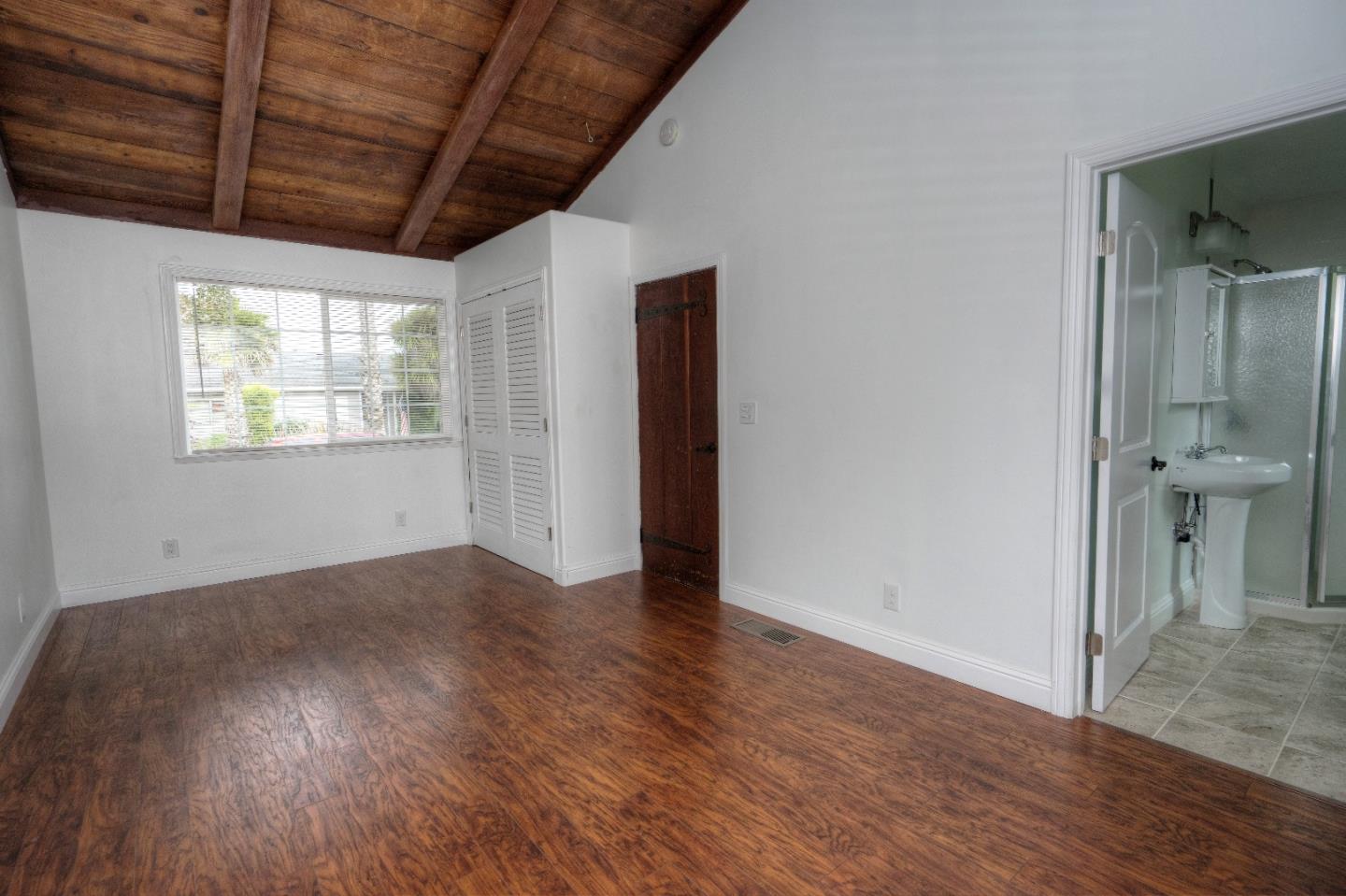 197 Ramona Avenue Pacifica, CA 94044 - Photo 17 of 26 an empty room with wooden floor and windows
