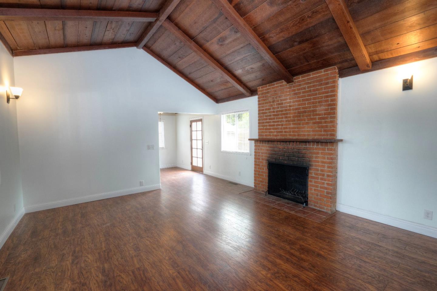 197 Ramona Avenue Pacifica, CA 94044 - Photo 5 of 26 a view of an empty room with wooden floor and a fireplace