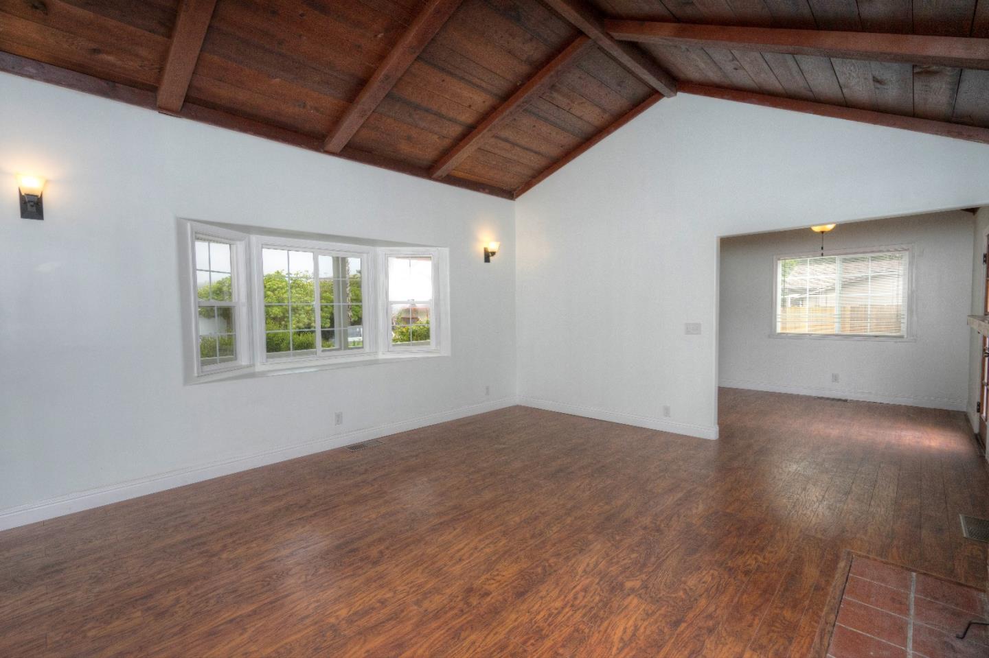 197 Ramona Avenue Pacifica, CA 94044 - Photo 6 of 26 a view of an empty room with wooden floor and a window