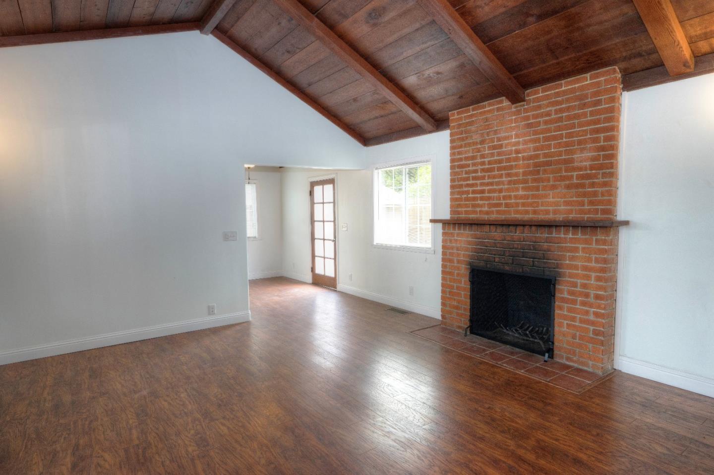 197 Ramona Avenue Pacifica, CA 94044 - Photo 8 of 26 an empty room with wooden floor fireplace and windows