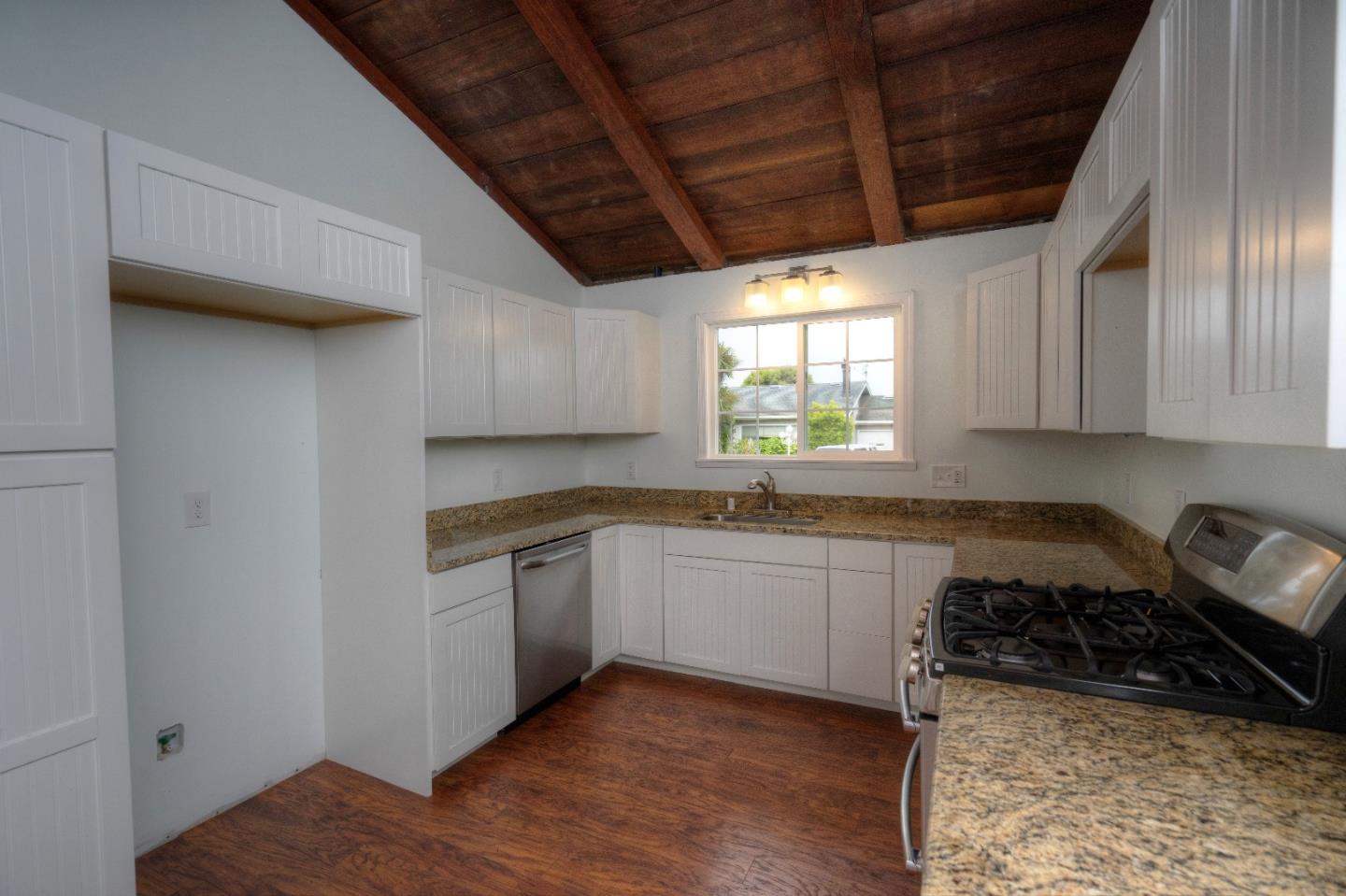 197 Ramona Avenue Pacifica, CA 94044 - Photo 10 of 26 a kitchen with granite countertop a sink a stove and cabinets