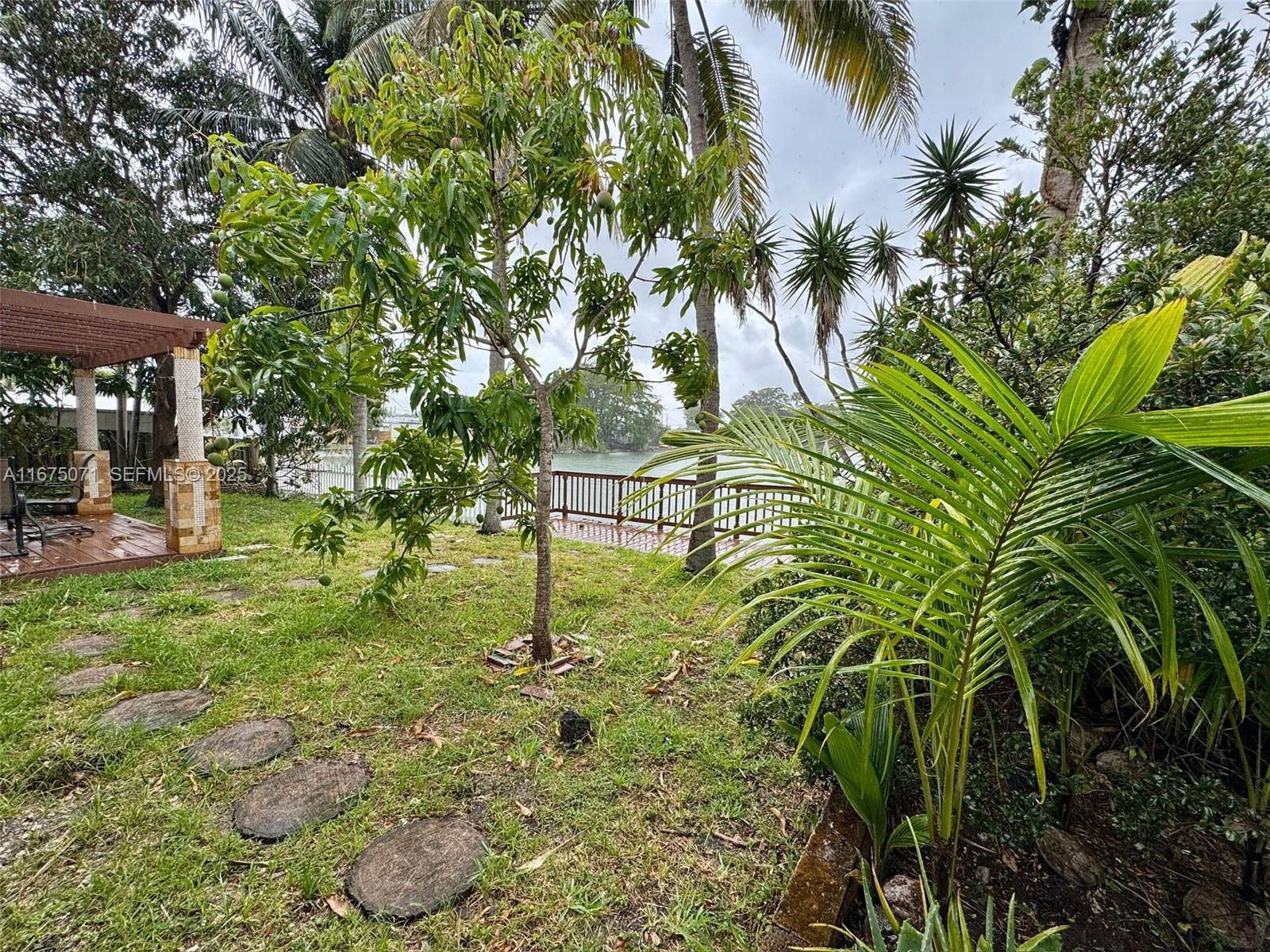 232 Southwest 7th Avenue Hallandale Beach, FL 33009 - Photo 24 of 48 a backyard of a house with table and chairs under an umbrella